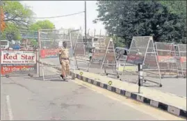  ?? ?? Police personnel stand guard near Kali Devi Temple to maintain law and order a day after violence in Patiala on Saturday; and (right) Shiv Sena leader Harish Singla comes out of the district courts complex following his arrest.