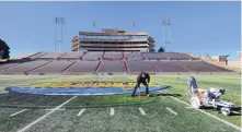  ?? ADOLPHE PIERRE-LOUIS/JOURNAL ?? Leroy Tapia puts the finishing touches on the New Mexico Bowl logo at the Dreamstyle Stadium on Thursday. This year’s bowl pits North Texas against Utah State.