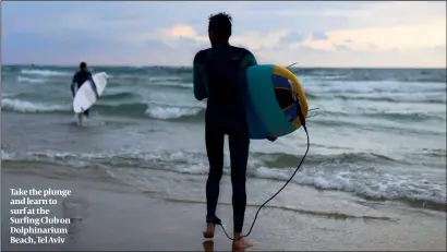  ?? PHOTO: FLASH90 ?? Take the plunge and learn to surf at the Surfing Club on Dolphinari­um Beach, Tel Aviv