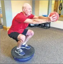  ??  ?? Stuart Eiche does a set of exercises designed to strengthen muscles often used while playing golf at Privato Personal Fitness.