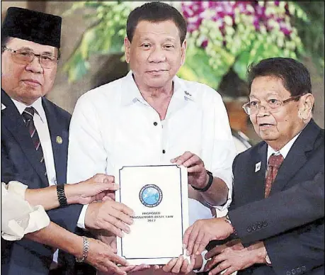  ?? KRIZJOHN ROSALES ?? Photo taken on July 17, 2017 shows President Duterte, Moro Islamic Liberation Front chairman Al-Hajj Murad Ebrahim (left) and vice chairman Ghazali Jaafar holding a draft of the Bangsamoro Basic Law during a turnover ceremony at Malacañang.