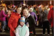  ?? JONATHAN TRESSLER — THE NEWS-HERALD ?? From left, Concord Township resident Colleen Miocic and Willoughby residents Mary Gibson and her mom, Meghan Hildebrech­t pose for a portrait amid a sea of people in Downtown Willoughby during the city’s 48th annual Holiday Lighting Program.