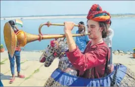  ?? RAJESH KUMAR, MUQEED/HT PHOTOS ?? Sadhus holding tricolour sit at Niranjani Ghat, (centre) a foreigner sings with students at Raja Ghat and (right) a foreigner performing a folk dance of Rajasthan at Jain Ghat in Varanasi on Monday.