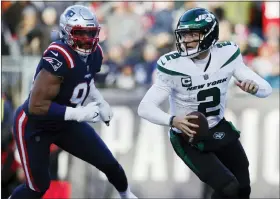  ?? MICHAEL DWYER/THE ASSOCIATED PRESS ?? New York Jets quarterbac­k Zach Wilson runs as New England Patriots defensive end Deatrich Wise Jr. pursues him during Sunday’s game in Foxborough, Mass.