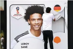  ?? FEDERICO GAMBARINI/DPA VIA AP ?? SISAKAN POLEMIK: Petugas mengganti poster bergambar Leroy Sane di dinding Museum Sepak Bola Jerman, Dortmund (5/6).
