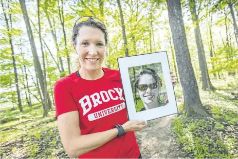  ?? BOB TYMCZYSZYN/POSTMEDIA NEWS ?? Emily Allan plans to run the 895-kilometre Bruce Trail to raise funds and awareness for cystic fibrosis. Here she holds a photo of her cousin and friend Sarah Bloomfield, who died because of the disease.