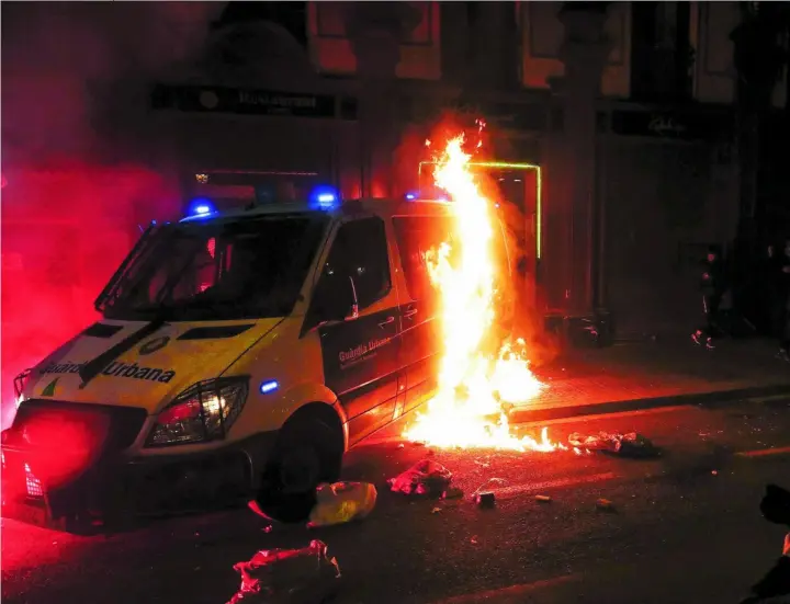  ?? REUTERS ?? Los violentos incendiaro­n un vehículo de la Guardia Urbana en Las Ramblas