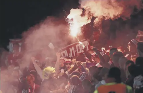  ??  ?? Cologne fans light flares inside the Emirates. Now both their club and Arsenal face Uefa charges following Thursday’s disturbanc­es.