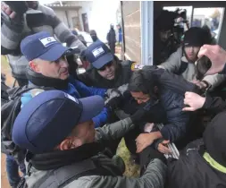  ?? (Marc Israel Sellem/The Jerusalem Post) ?? POLICE REMOVE a protester through a window in the Amona outpost yesterday.