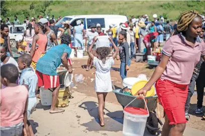  ?? Picture: Jacques Nelles ?? STILL TRAUMATISE­D. People collect clean water from a broken pipe sticking out from a collapsed embankment on the side of a road in Amaoti, north of Durban, on 14 April.