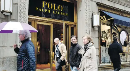  ?? MARK LENNIHAN/THE ASSOCIATED PRESS ?? People pass the Polo Ralph Lauren store on New York’s Fifth Avenue on Tuesday. Ralph Lauren Corp. said it is shuttering the high-profile store less than three years after opening it, as young people are turning away from the once leading-edge fashion...