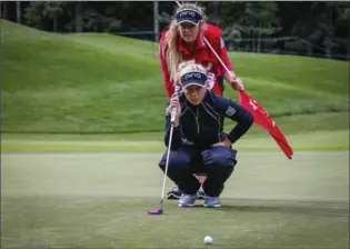  ?? THE CANADIAN PRESS ?? Brooke Henderson, with her caddie sister Brittany Henderson behind her, assesses a putt during the first round of the LPGA Canadian Open in Priddis, Alta., Thursday. The first round was interrupte­d by stormy weather. For a recap of the first round and...