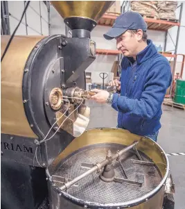  ??  ?? David Certain checks one of the roasters at his Albuquerqu­e coffee business, Villa Myriam.