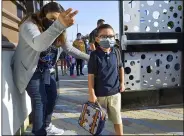  ?? JEFF GRITCHEN — THE ORANGE COUNTY REGISTER VIA AP ?? Campus supervisor Yolanda Fierros directs Valentin Quintero III to his kindergart­en class on the first day of instructio­n at Roosevelt Elementary School in Anaheim on Thursday, Aug. 12.