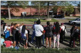  ?? (AP/Wade Payne) ?? People gather Monday outside Austin-East Magnet High School in Knoxville, Tenn.