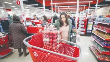  ?? — Reuters ?? A customer loads her shopping cart during the Black Friday sales event on Thanksgivi­ng Day at Target in Chicago