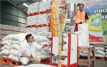  ?? FRIZAL/JAWA POS ?? KEMASAN KECIL: Pegawai Bulog mengoperas­ikan mesin pengemas beras sachet 200 gram di gudang Perum Bulog Subdivre Surabaya Utara kemarin (6/7).