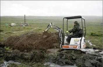  ?? AP FILE PHOTO/AL GRILLO ?? In this July 13, 2007 file photo, a worker with the Pebble Mine project digs in the Bristol Bay region of Alaska near the village of Iliamma, Alaska. The Trump administra­tion settled a lawsuit on Friday, over the proposed developmen­t of a massive...