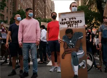  ?? Spencer Platt/Getty Images ?? A protester in New York displays a drawing of Colin Kaepernick, who in 2016 took a knee during the national anthem before NFL games to draw attention to police brutality and racial injustice.