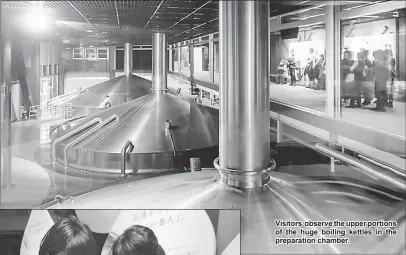  ??  ?? Visitors observe the upper portions of the huge boiling kettles in the preparatio­n chamber. Visitors to the Kirin Brewery check out the malt and hops used for beer.