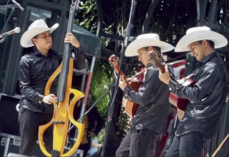  ?? JULIA MALAKIE / LOWELL SUN ?? Grupo cimarron performs colombian joropo music at Boarding house Park at the Lowell Folk Festival in July 2019.