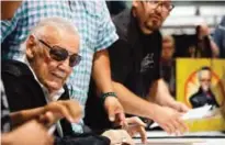  ?? — AP photos ?? Stan Lee, left, signs autographs at Boston Comic Con, in Boston.