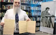  ?? SEBASTIAN SCHEINER/ASSOCIATED PRESS ?? Hebrew University’s Roni Gross, left, holds the original historical documents related to Albert Einstein’s prediction of the existence of gravitatio­nal waves at the Hebrew University in Jerusalem on Thursday. Meanwhile, LIGO co-founder Kip Thorne speaks about the discovery on Thursday.