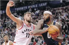  ?? NATHAN DENETTE / THE CANADIAN PRESS ?? Jonas Valanciuna­s looks to block New Orleans centre DeMarcus Cousins at the Air Canada Centre on Thursday.