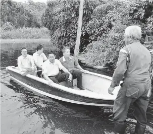  ??  ?? NAIK PERAHU: Tiang (belakang, kiri), Lau (belakang, dua kiri), Ting (depan, kiri) serta yang lain terpaksa menggunaka­n perahu untuk masuk ke lorong ketika mengadakan tinjauan banjir di Kampung Bahagia Jaya, Teku di Sibu, semalam.