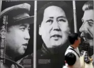  ?? LEE JIN-MAN — THE ASSOCIATED PRESS FILE ?? In this file photo, visitors look at posters of the late leaders, from left, of North Korea’s Kim Il Song, China’s Mao Zedong and Russia’s Joseph Stalin at a Korean War exhibition in Seoul, South Korea.