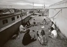  ?? Filippo Monteforte / AFP via Getty Images ?? University students share aperitivos atop their apartment building in Rome’s San Lorenzo University district Saturday.