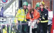  ?? SKY VIA AP ?? A woman is helped by emergency personnel after a bomb exploded on a subway train at London’s Parsons Green station on Friday morning. Over 20 people were treated for injuries, mostly burns. The attack was being treated as terrorism and police were...