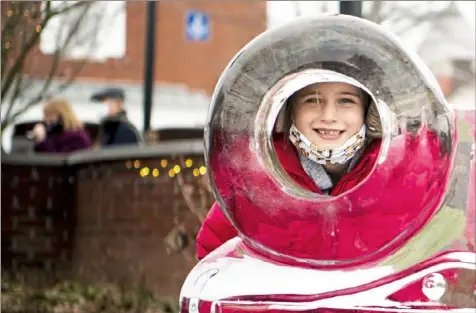  ?? Alexandra Wimley/Post-Gazette ?? Grace Guzzie, 7, of Greensburg, stands behind an ice sculpture Jan. 24 at the 30th annual Ligonier Ice Fest, which featured 84 hand-crafted carvings along the streets of Ligonier.