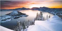  ?? ASSOCIATED PRESS FILE PHOTOS ?? The sun rises over Crater Lake, Ore., in Crater Lake National Park. Below: A rare “super bloom” of wildflower­s in Death Valley National Park covered the hottest and driest place in North America with a carpet of gold this February in California.