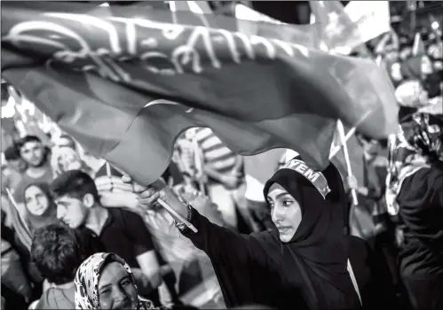  ??  ?? A woman waves flags during a pro- Erdogan rally in Taksim square in Istanbul on Friday following the failed military coup attempt of July 15. Turkey detained 283 members of the presidenti­al guard of Recep Tayyip Erdogan after last week’s attempted...