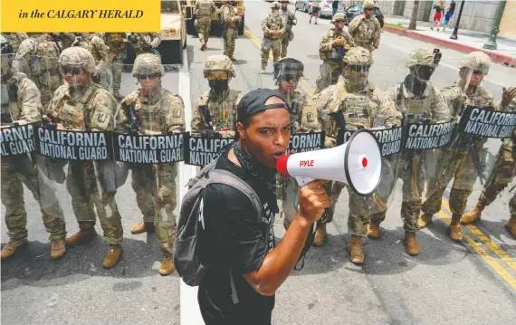  ?? KYLE GRILLOT / AFP VIA GETTY IMAGES ?? A protester speaks in front of the California National Guard during a demonstrat­ion in Los Angeles on Tuesday over the death of George Floyd while in police custody.