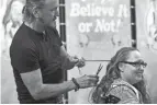  ?? PHOTOS BY FRED SQUILLANTE ?? Cambridge hairstylis­t Steve Warden cuts a lock of hair from a customer to be added to Hoss. His four children had begged him for years to make a hair ball big enough to be featured in a Ripley's Believe It or Not! book.