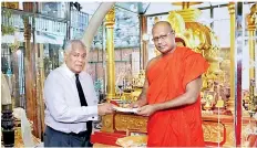  ??  ?? Ajita de Zoysa, Chairman of The Kalutara Bodhi Trust and Chairman World Peace Associatio­n Sri Lanka present the cheque to Ven. Kirinde Assaji Thera of the Gangaramay­a Temple.