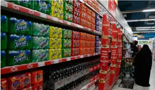  ?? — Reuters ?? A customer shops for soft drinks at a grocery store in Dubai.