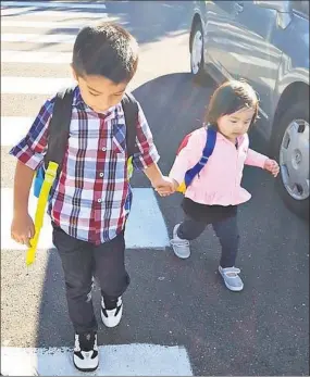  ??  ?? Two IRIS students are prepared for school with their backpacks.