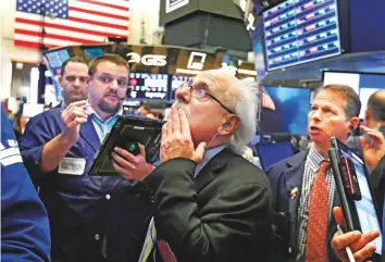 ?? AP ?? Traders at the New York Stock Exchange. Wall Street was back in aggressive sell-off mode on Friday, with major stock indices losing more than two per cent.