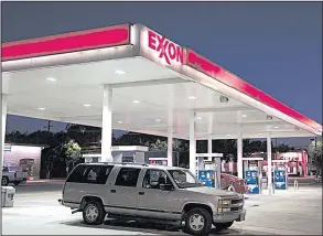  ?? Bloomberg News/COOPER NEILL ?? A vehicle leaves an Exxon Mobil gas station in Dallas. Exxon said Friday that higher prices for oil and gas helped it offset a 1 percent decline in production.