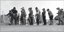  ?? [ERIC GAY/ THE ASSOCIATED PRESS] ?? Migrants seeking asylum in the United States line up for a meal provided by volunteers near the internatio­nal bridge in Matamoros, Mexico.