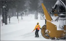  ?? BRIAN VAN DER BRUG/LOS ANGELES TIMES ?? A Mammoth Mountain employee directing traffic is dwarfed by a snow removal vehicle on Minaret Road leading to Mammoth Mountain ski area in Mammoth Lakes on Jan. 10.