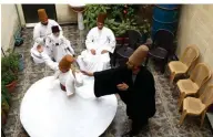  ??  ?? Sufi Dervish dancer Mahmoud Al-Kharrat (right), 34, guides other members of his family as they dance at a courtyard in their house.