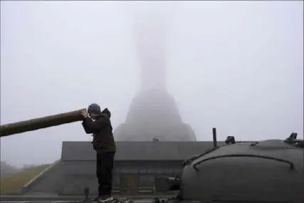  ?? Alex Babenko/Associated Press ?? A boy plays on a tank in Kyiv, Ukraine, in front of the Motherland monument. which reopened for public viewing Saturday.