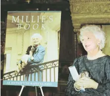  ?? AP FILE PHOTO ?? MILLIE’S GHOSTWRITE­R: First lady Barbara Bush holds a rawhide bone as she stands next to an illustrati­on of ‘Millie’s Book’ in a 1990 photo.