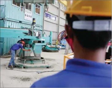  ?? HONG MENEA ?? A worker operates machinery at a precast plant in Phnom Penh’s Russeo Keo district in 2015.