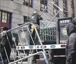  ?? Seth Wenig Associated Press ?? BARRICADES are unloaded from a truck outside the Manhattan courthouse where former President Trump would appear if he were indicted by a grand jury.