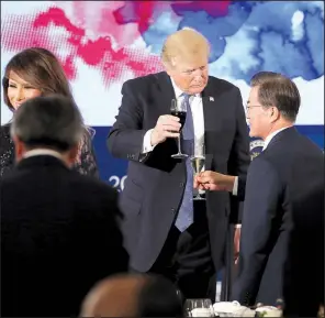  ?? AP/ANDREW HARNIK ?? President Donald Trump shares a toast with South Korean President Moon Jae-in before a state dinner Tuesday in Seoul. Trump softened his rhetoric on North Korea as he met with Moon.